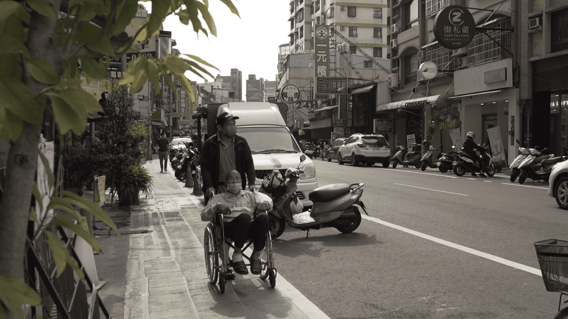 高雄市前鎮區的德祥路劃設人行道之後，輪椅人士不必走在車道上與汽機車爭道，同時外側臨停車輛也能保護內側的行人。（攝影／許家嘉）