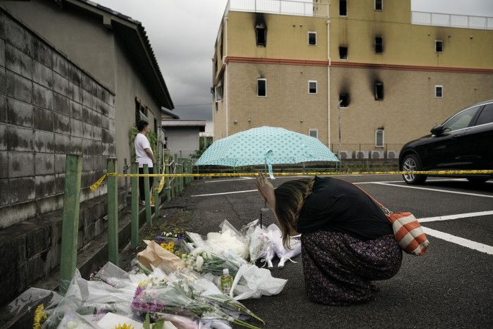民眾在燒毀的京都動畫工作室旁，獻上花束，為受傷的員工祈禱(圖片來源：美聯社)
