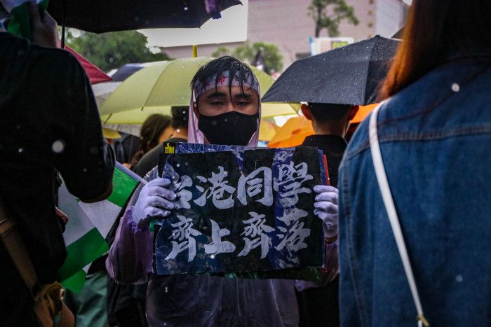 有參與遊行的民眾手持「台港同學，齊上齊落」的標語。