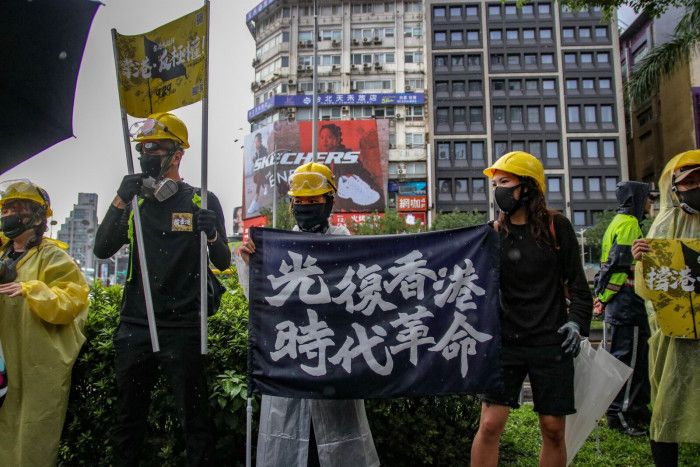 香港遊行人士持「光復香港，時代革命」標語。