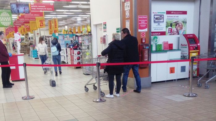 波蘭購物賣場在入口處地板貼標示線，管制民眾進出。