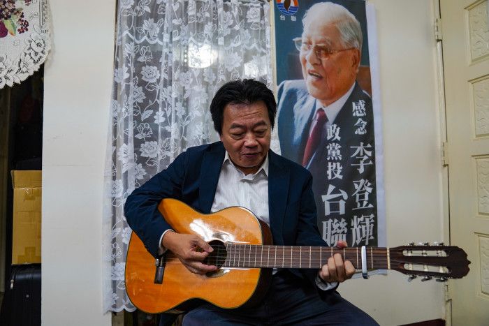 訪談結束後，劉一德拿起一旁的吉他，坐在李登輝的旗幟旁，彈起一首首七〇年代的台語歌謠，餘音在黨部辦公室中緩緩迴盪。（攝／梁駿樂）