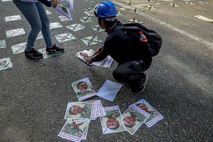 緬甸街頭被示威者貼滿軍事頭子敏昂萊（Min Aung Hlaing）的照片。 （圖／AP）