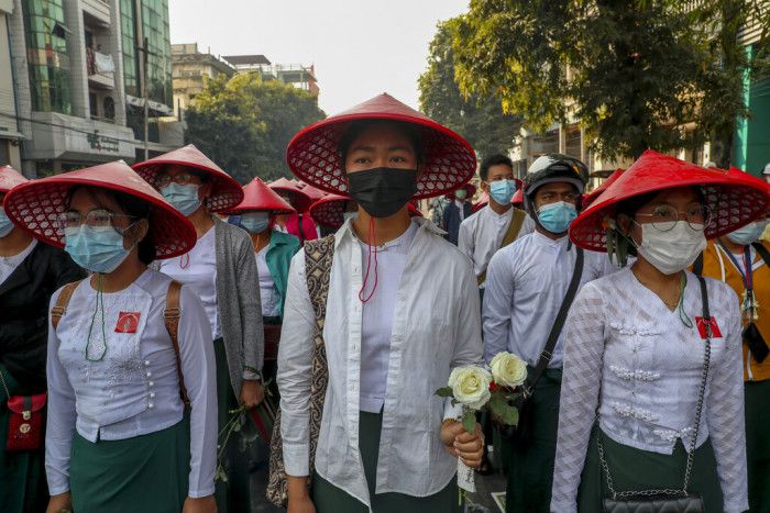 學校教師穿著制服、戴上緬甸的傳統帽子，在遊行隊伍中響應公民不服從運動。 （圖／AP）