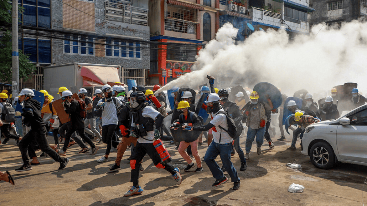 在仰光市區，示威民眾躲避警方的催淚彈。 （圖／AP）
