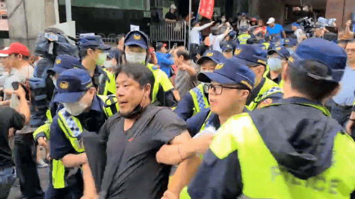在高雄市長罷免案通過後，杏仁哥與其他韓國瑜支持者前往桃園市議員王浩宇服務處抗議，並與警方爆發肢體衝突。（截自公視新聞畫面）