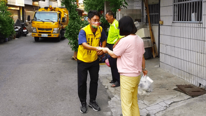時代力量嘉義市西區議員候選人王浩勤走基層，沿街向丟垃圾的民眾握手致意。（攝影／李金龍）
