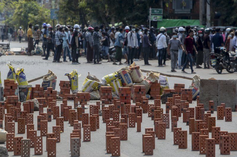 緬甸抗爭者學習香港抗爭者，堆磚頭阻擋軍警向前鎮壓。（圖／美聯社）